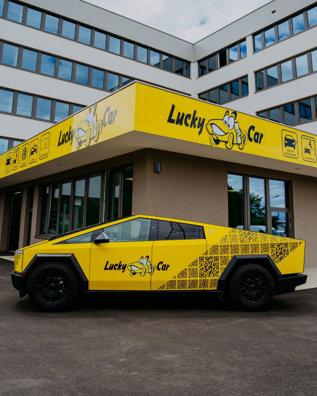 Gelber Lucky-Car-Cybertruck vor Werkstattgebäude
