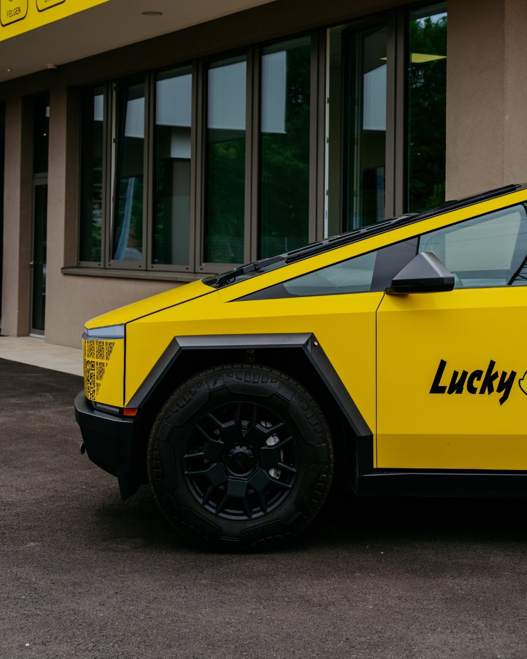 Gelbes Elektroauto vor modernem Gebäude