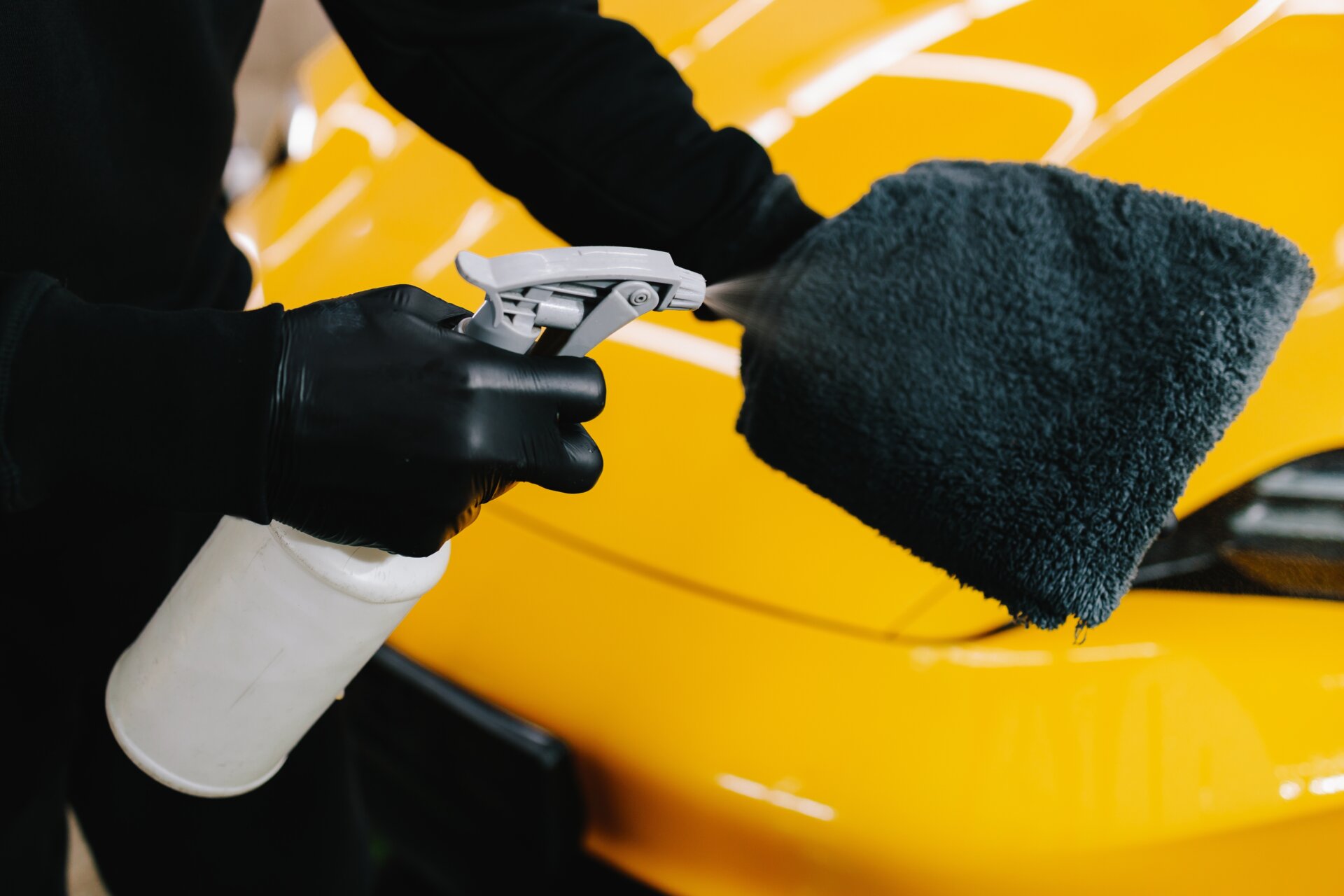 Auto Lackpflege mit Sprühflasche auf Mikrofasertuch