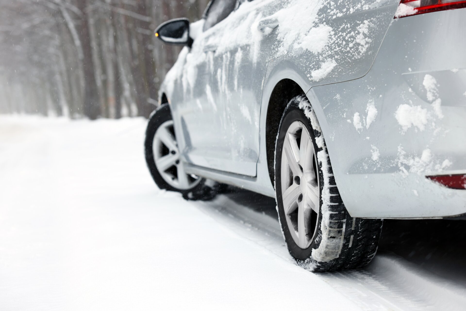Auto mit Winterreifen auf verschneiter Straße